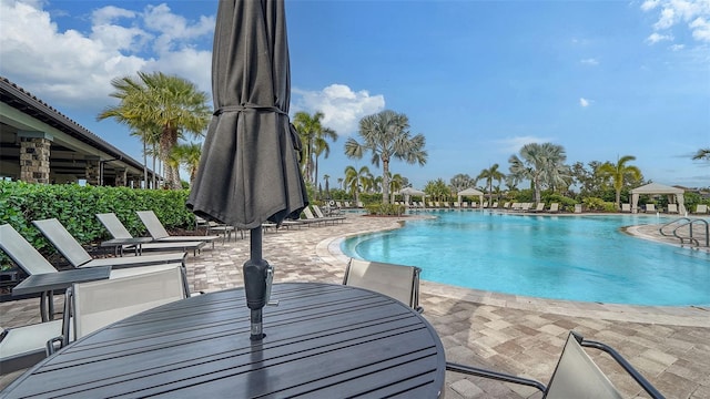 community pool featuring outdoor dining area and a patio area