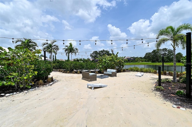 view of patio / terrace with a fire pit, a water view, and fence