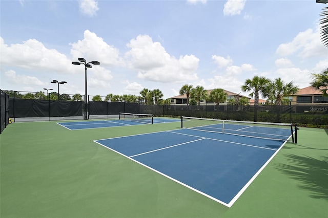 view of tennis court with community basketball court and fence