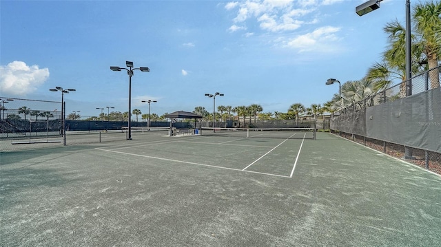 view of tennis court featuring fence