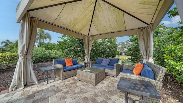 view of patio featuring a gazebo, fence, and an outdoor living space