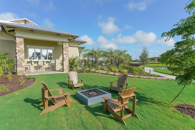 view of yard featuring a water view and an outdoor fire pit