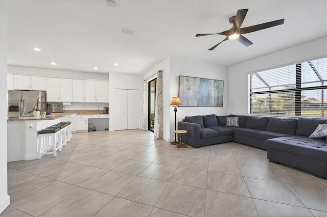 tiled living room with ceiling fan