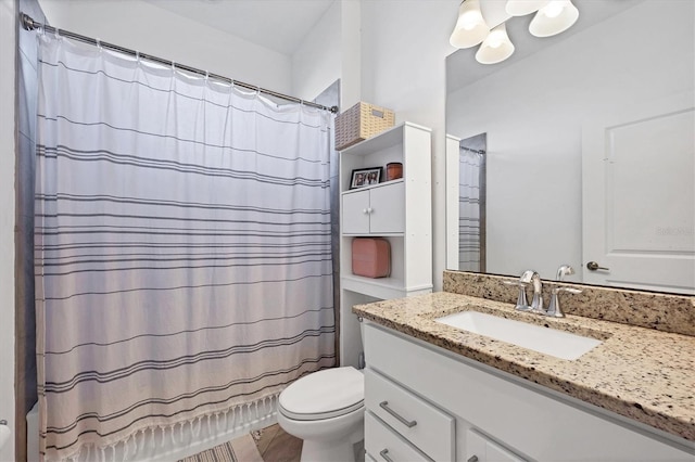 bathroom featuring a shower with shower curtain, vanity, and toilet