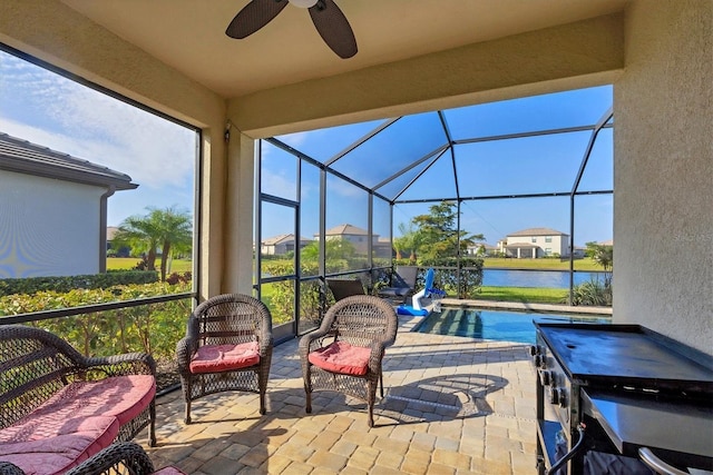 view of patio / terrace with a water view, ceiling fan, and a lanai