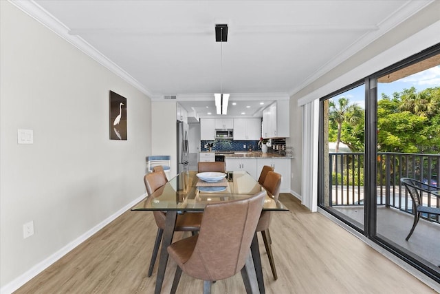 dining area featuring crown molding and light hardwood / wood-style floors