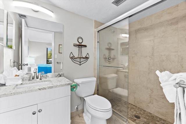 bathroom with a textured ceiling, toilet, walk in shower, and vanity