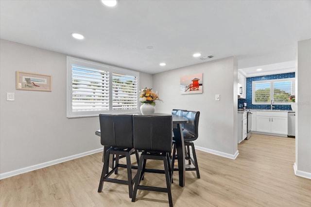 dining area featuring sink and light wood-type flooring