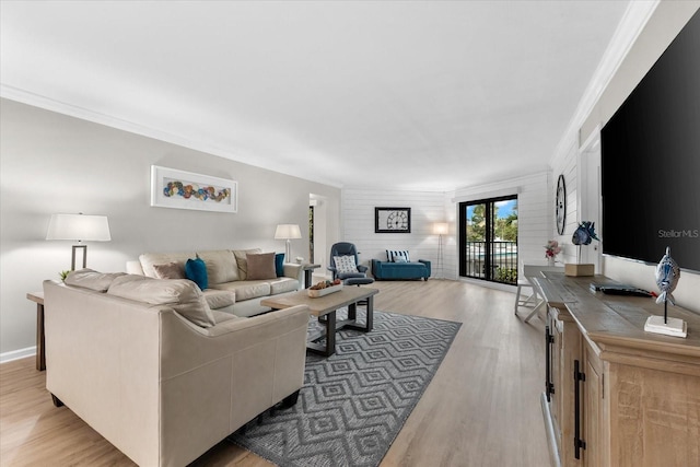 living room with french doors, crown molding, and light hardwood / wood-style flooring