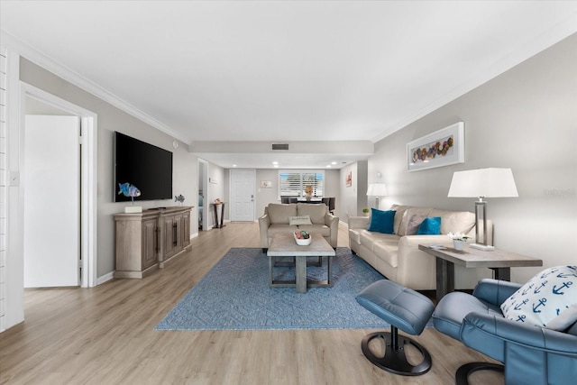 living room featuring ornamental molding and light hardwood / wood-style floors