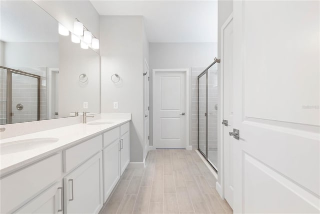 bathroom with vanity and a shower with door