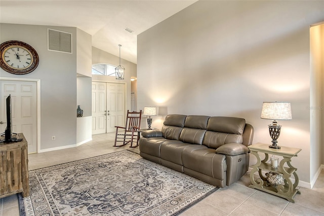 living room with light tile patterned floors and high vaulted ceiling