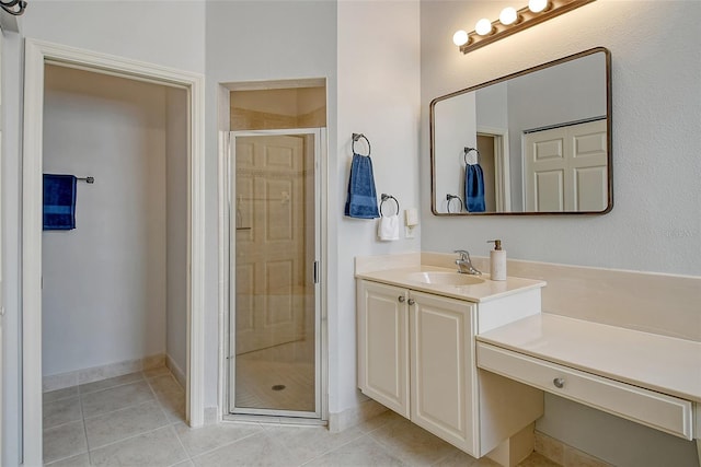 bathroom featuring tile patterned flooring, vanity, and a shower with door