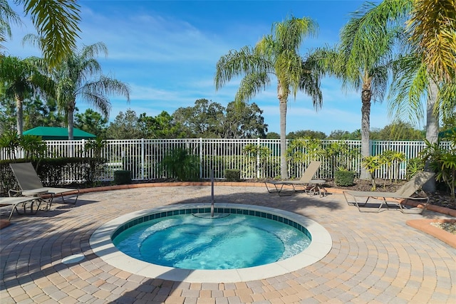 view of swimming pool featuring a patio and a hot tub