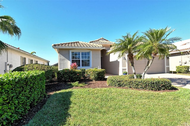 mediterranean / spanish-style house featuring a front lawn and a garage