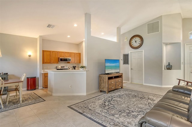 living room with light tile patterned floors and high vaulted ceiling