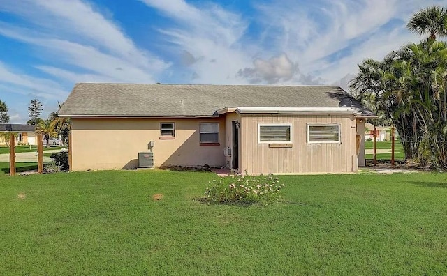 rear view of house with a yard and central air condition unit