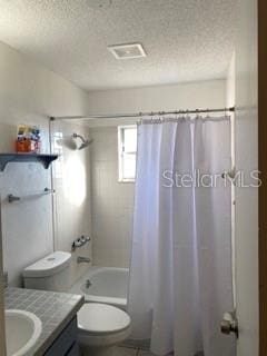 full bathroom with shower / bath combo, vanity, a textured ceiling, and toilet