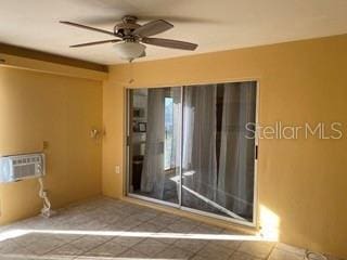 spare room featuring a wall mounted AC and ceiling fan