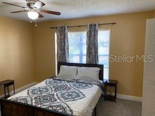 carpeted bedroom with a textured ceiling and ceiling fan