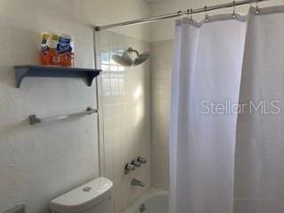 bathroom with shower / tub combo and toilet