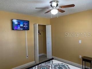 unfurnished bedroom with ceiling fan, a closet, and a textured ceiling