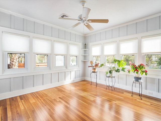 unfurnished sunroom with ceiling fan and plenty of natural light