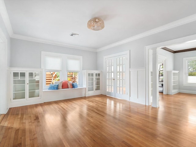 interior space with crown molding, french doors, and light hardwood / wood-style flooring