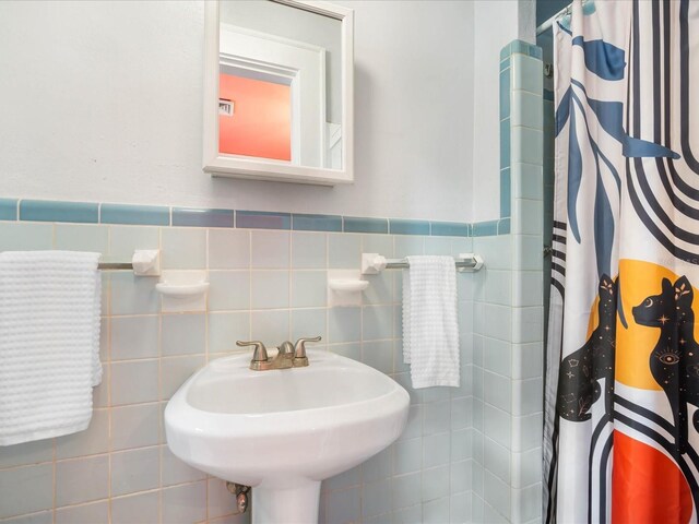 bathroom with tile walls and sink