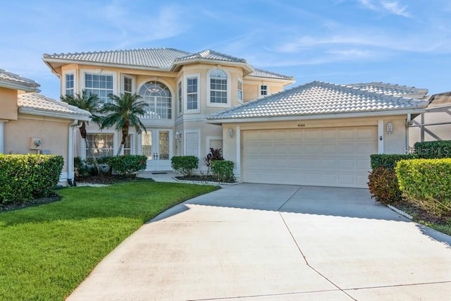 mediterranean / spanish house featuring a front lawn, a garage, and french doors