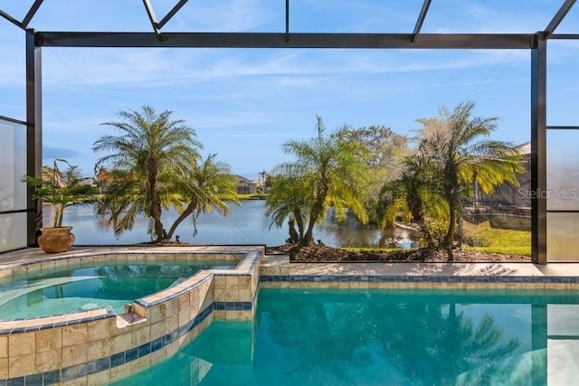 view of swimming pool featuring glass enclosure, a water view, and an in ground hot tub