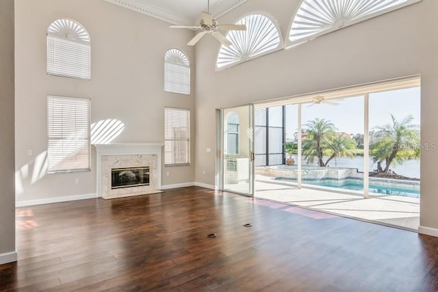 unfurnished living room with a towering ceiling, plenty of natural light, and crown molding