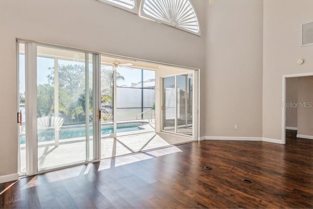 interior space featuring hardwood / wood-style floors, ceiling fan, and a high ceiling