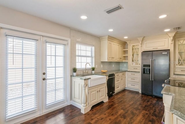 kitchen with light stone countertops, stainless steel refrigerator with ice dispenser, dark hardwood / wood-style flooring, and sink