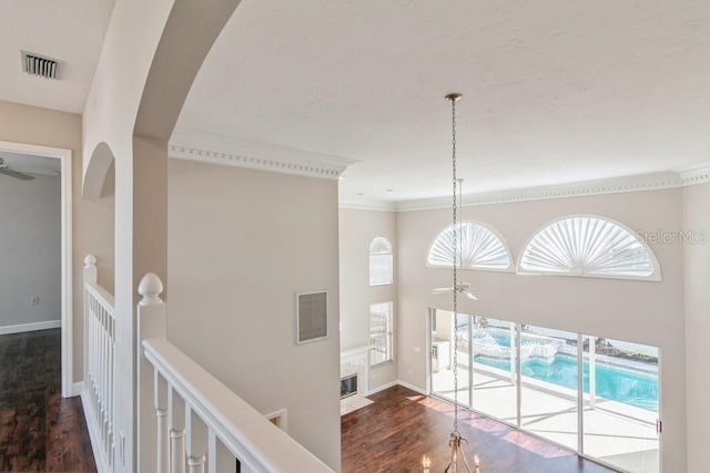 hall with ornamental molding and dark wood-type flooring