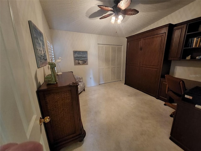 carpeted office featuring ceiling fan, lofted ceiling, and a textured ceiling