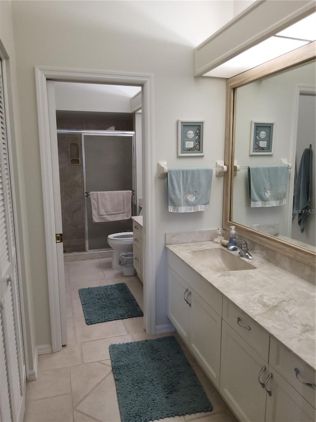 bathroom featuring tile patterned flooring, vanity, toilet, and walk in shower