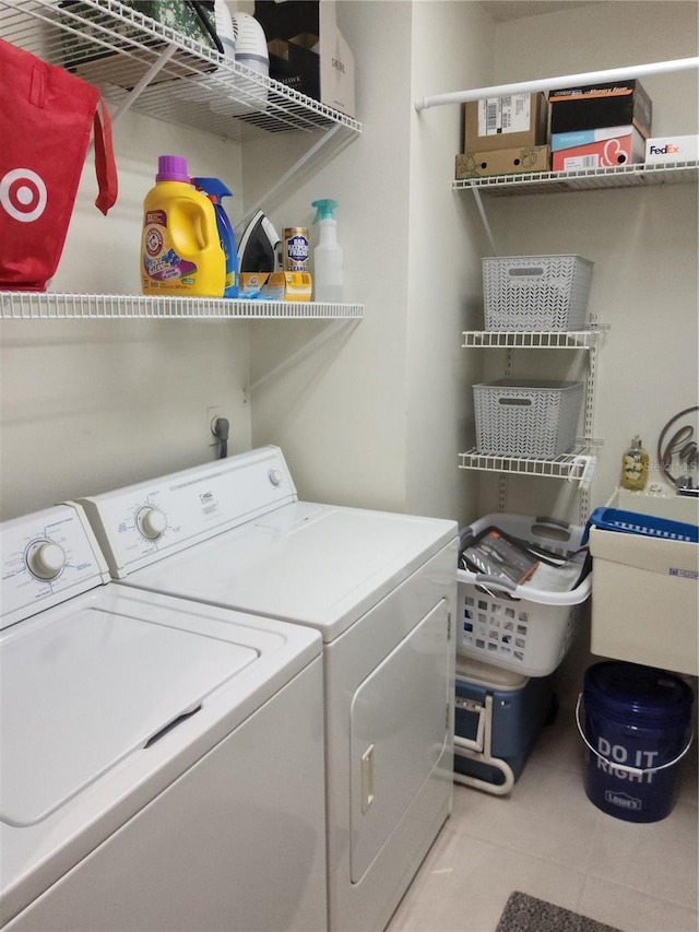 laundry room featuring washing machine and dryer and light tile patterned flooring