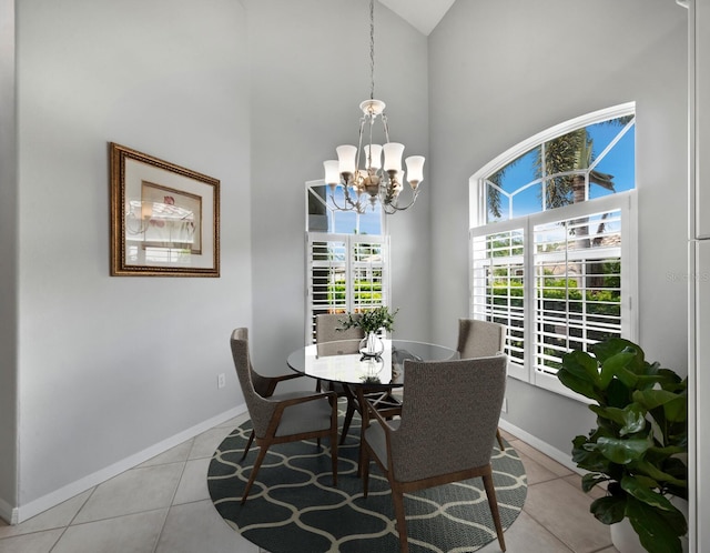 dining space with a notable chandelier, light tile patterned flooring, a towering ceiling, and a wealth of natural light