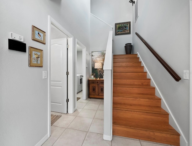 stairway with tile patterned floors and washing machine and clothes dryer