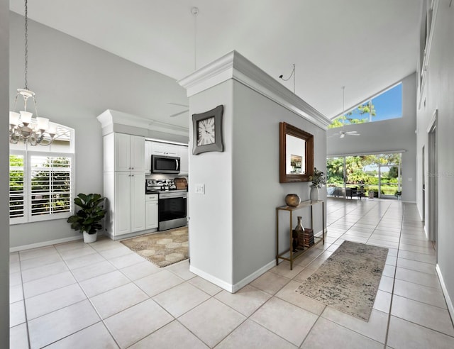 hall with light tile patterned flooring, a healthy amount of sunlight, and high vaulted ceiling