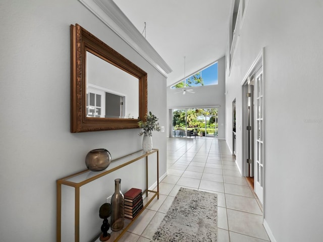 hall featuring light tile patterned floors and high vaulted ceiling