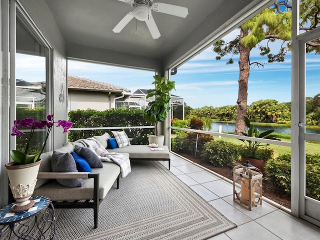 sunroom featuring a water view and ceiling fan