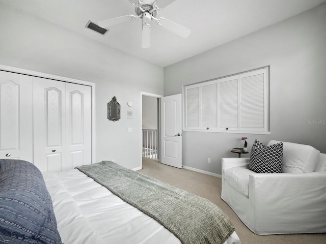 bedroom with ceiling fan, light carpet, and a closet