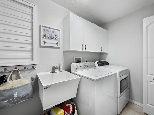 laundry room with separate washer and dryer, sink, light tile patterned floors, and cabinets