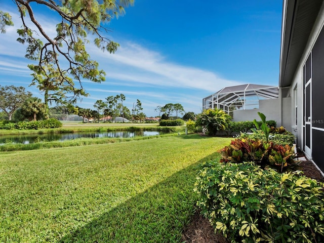 view of yard featuring glass enclosure and a water view