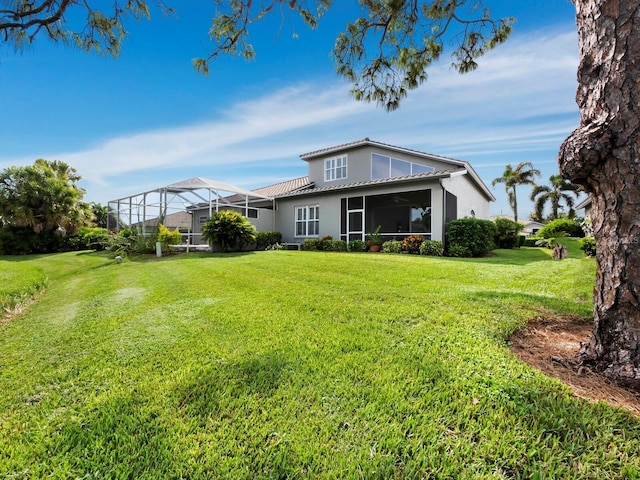 back of property with a lawn and glass enclosure