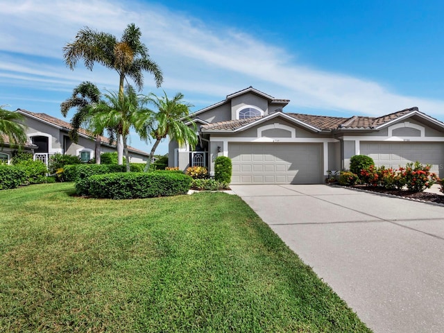 view of front facade featuring a garage, a tiled roof, driveway, stucco siding, and a front lawn