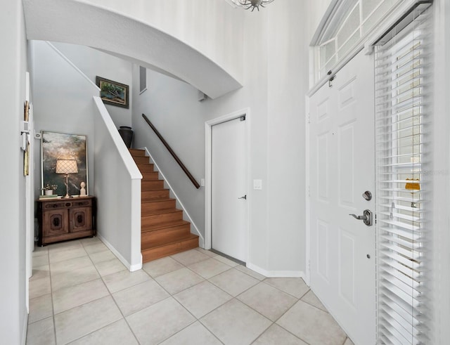8737 Pebble Creek Ln, Sarasota, FL 34238 - foyer featuring light tile patterned floors, stairway, baseboards, and arched walkways