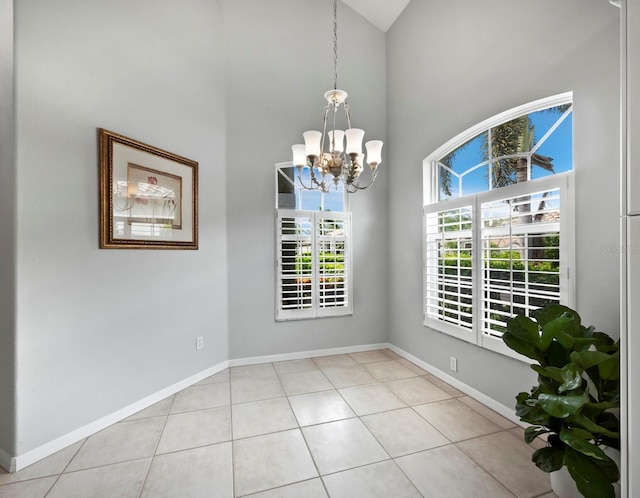 8737 Pebble Creek Ln, Sarasota, FL 34238 - unfurnished room featuring a chandelier, high vaulted ceiling, light tile patterned floors, and baseboards